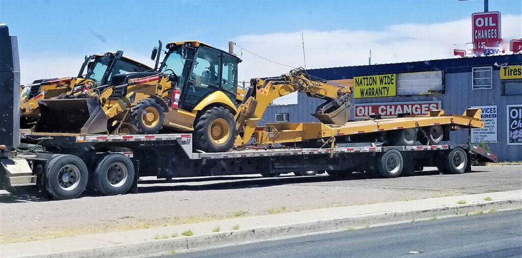 lowboy trailer with construction vehicles